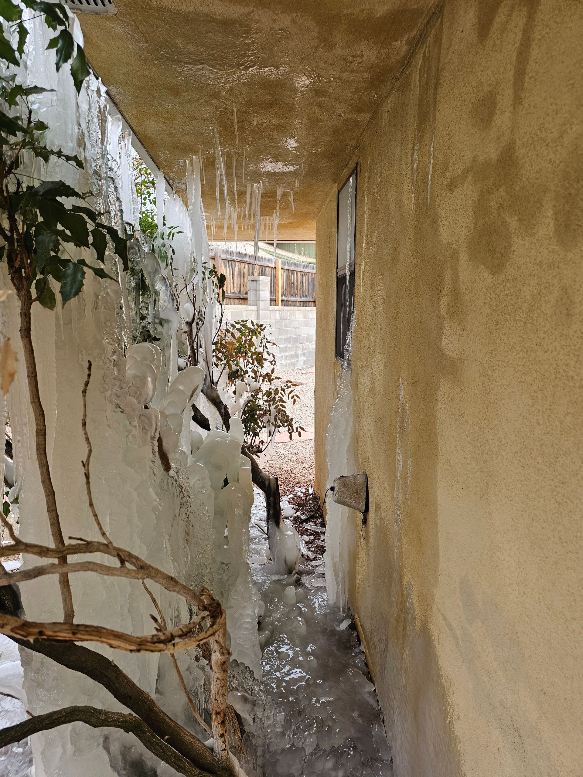 Ice formations on a building's exterior; icy water dripping.