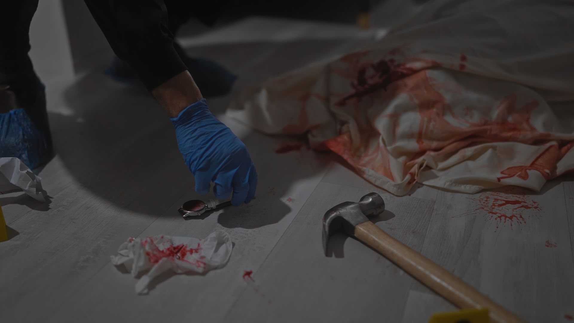 A person wearing green gloves is cleaning a white surface with a sponge.