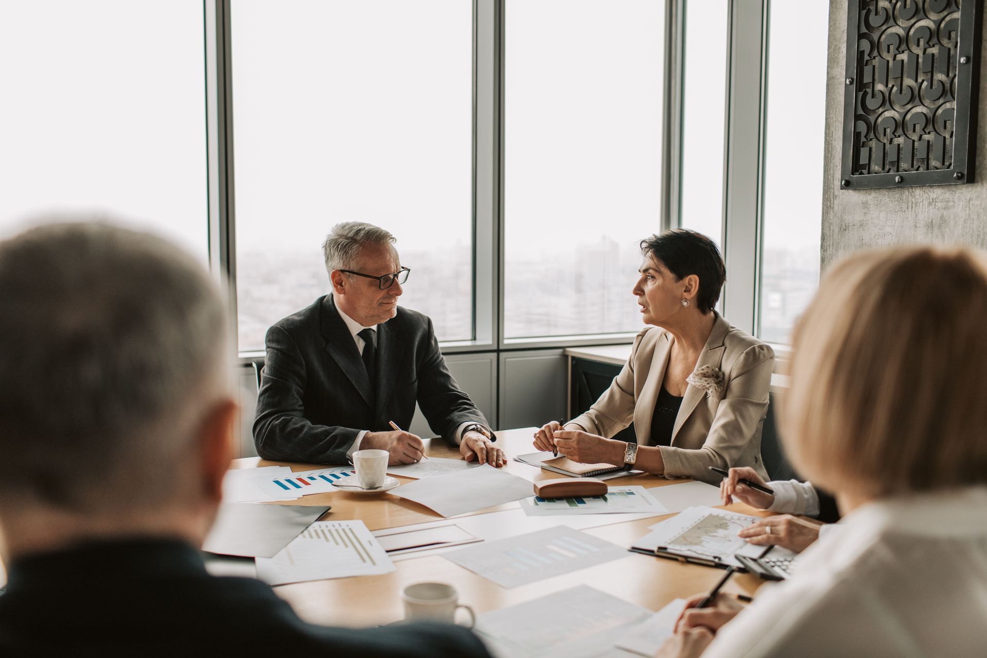 Business meeting with two people discussing documents at a conference table in a bright office