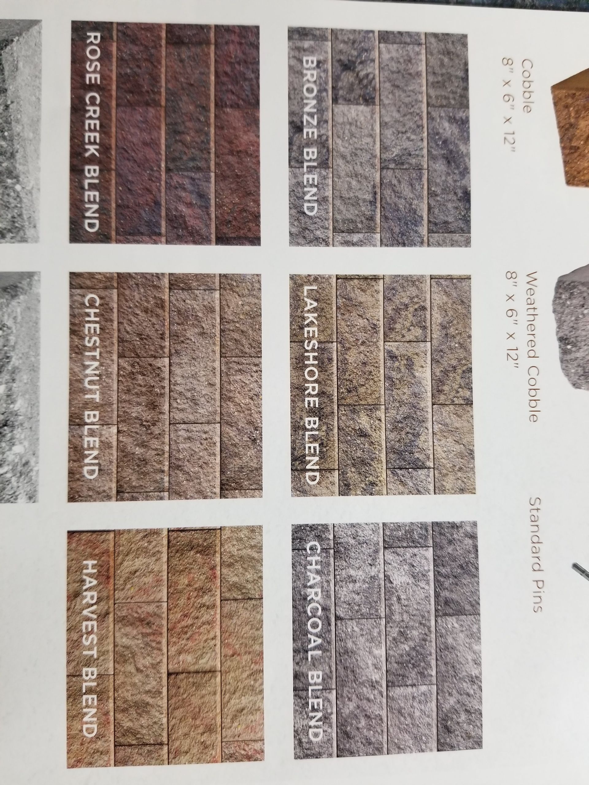 A display grid of six rectangular stone veneer samples in various colors, labeled Rose Creek, Bronze, Chestnut, Lakeshore, Harvest, and Charcoal.