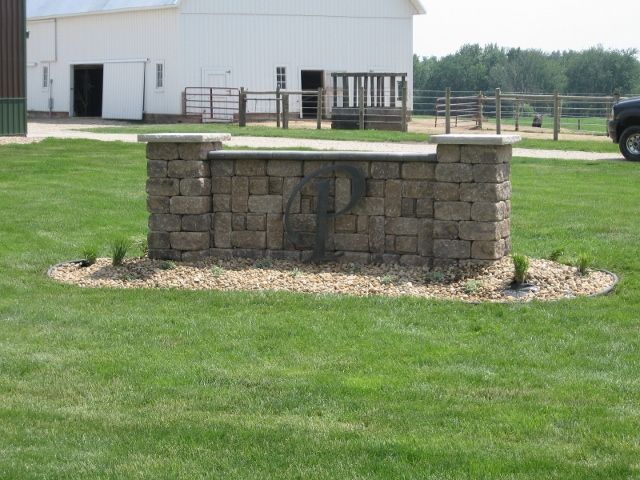 A tan stone sign with the metal monogram 
