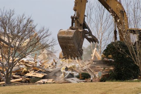 Bulldozer Removes the Debris From Demolition of Old Derelict Buildings