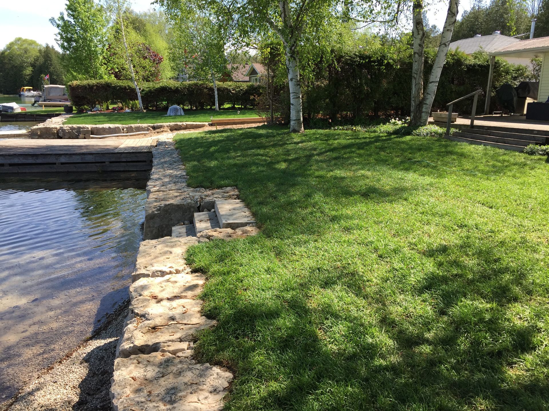 backyard having landscape construction with a retaining wall built from armorstone