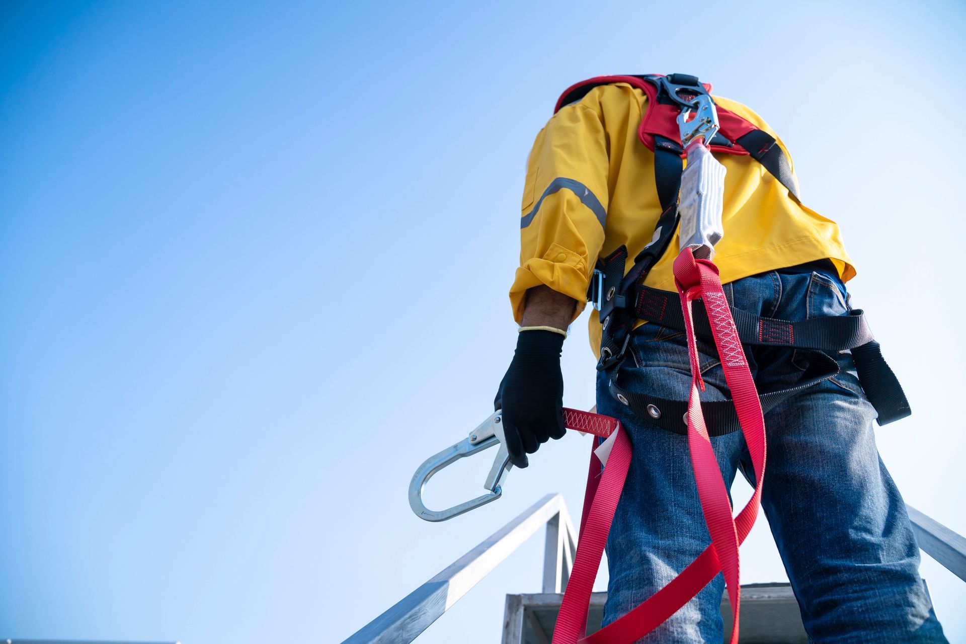 Un uomo che indossa un'imbracatura di sicurezza è in piedi su una scala.