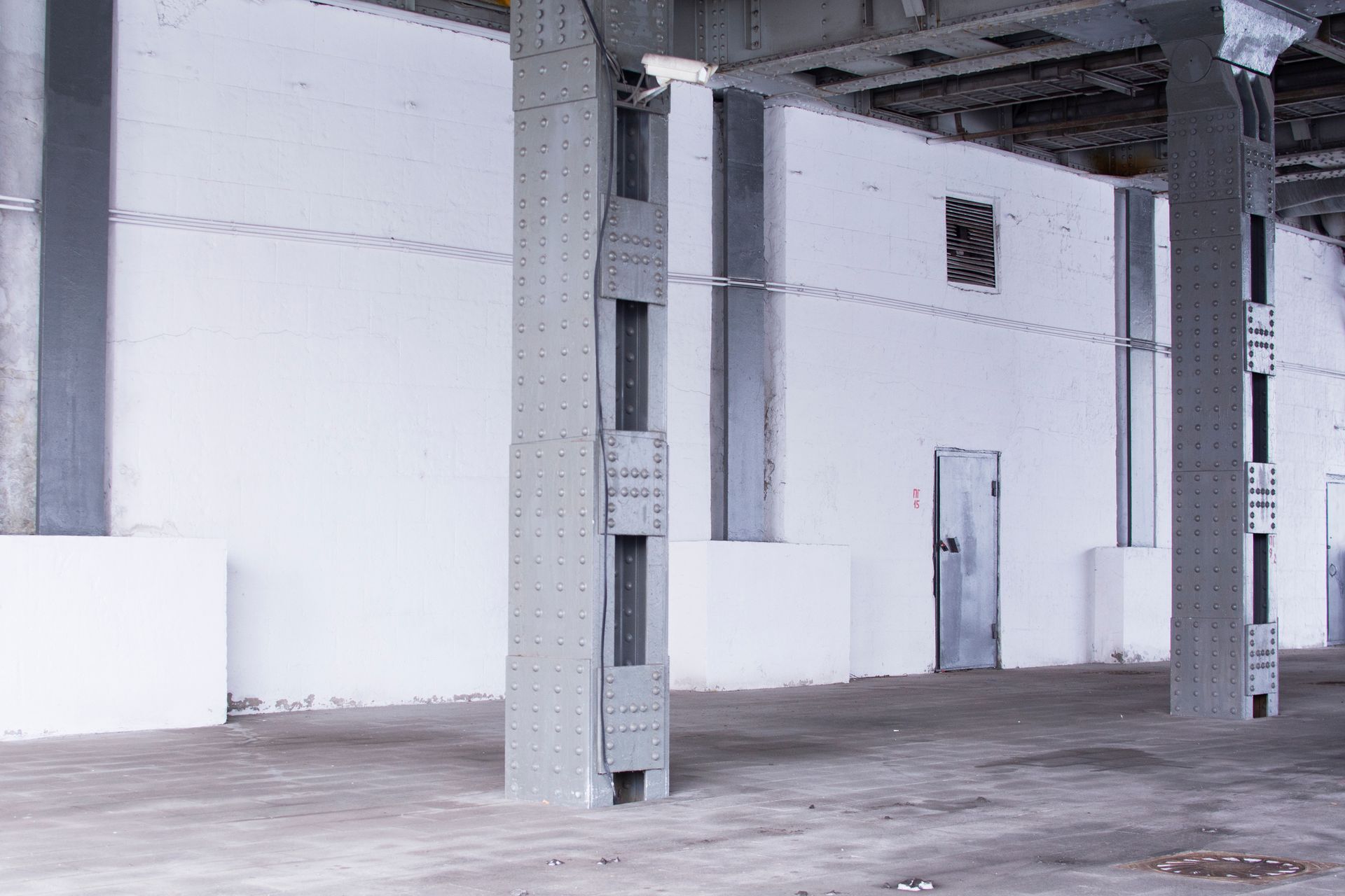 Un magazzino vuoto con pareti bianche e pilastri di metallo