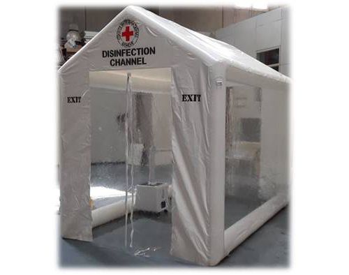 Una tenda bianca con una croce rossa è appoggiata su un pavimento di cemento.