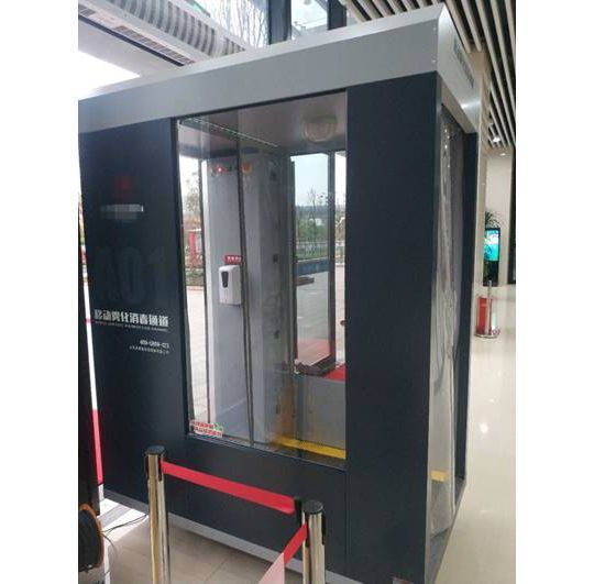 Un edificio nero e grigio con una porta di vetro e una barriera rossa.