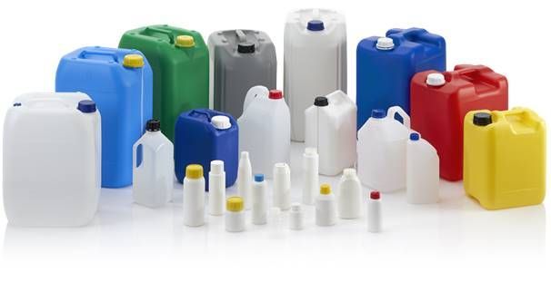 Una varietà di contenitori e bottiglie di plastica sono allineati su una superficie bianca.