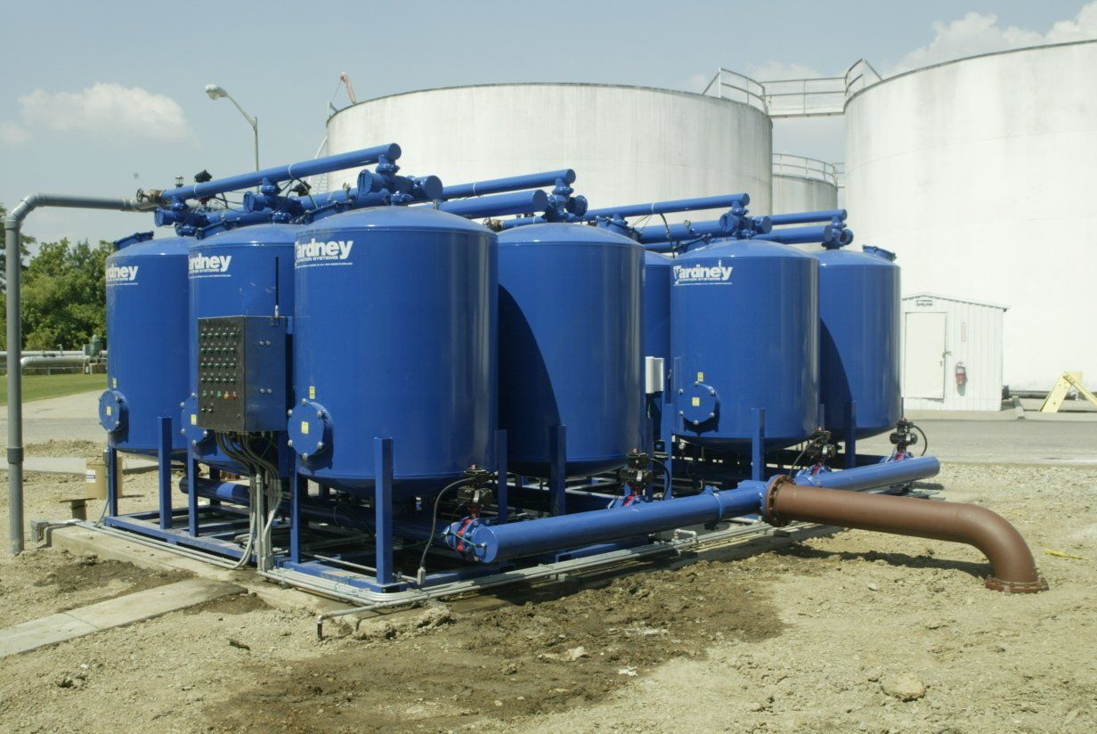 A bunch of blue tanks are lined up next to each other