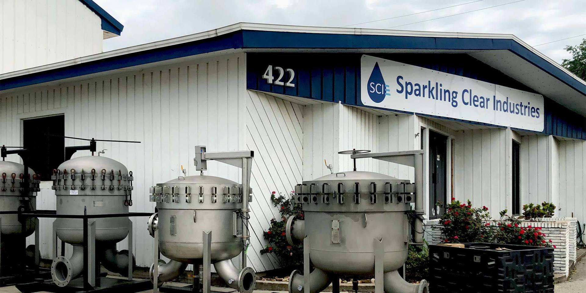 A white building with a sign that says sparkling clear industries