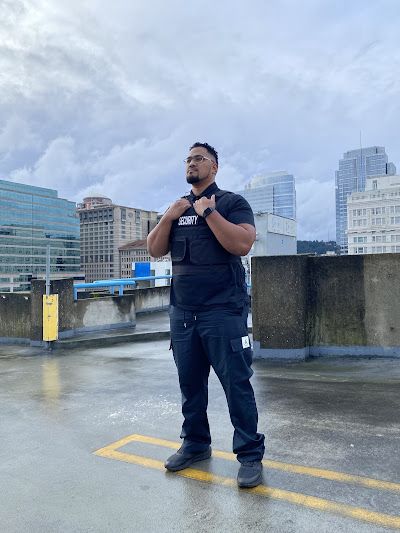 A man wearing a vest is standing in a parking lot.