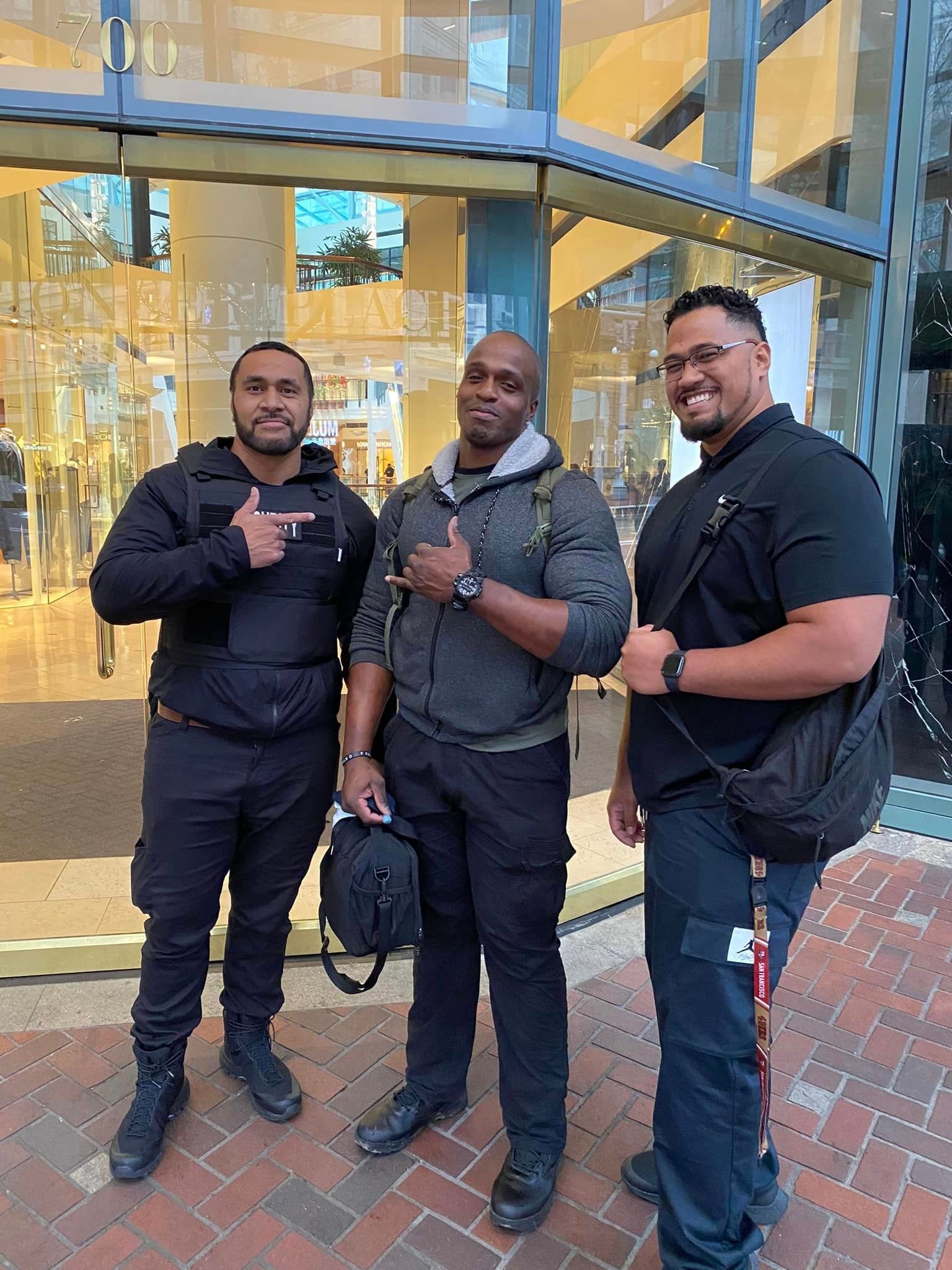 Three men are posing for a picture in front of a building.