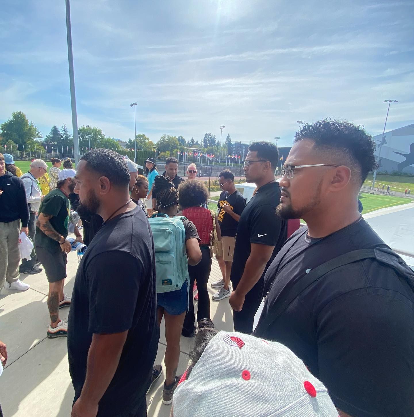 A group of people are standing in a line on a sidewalk.