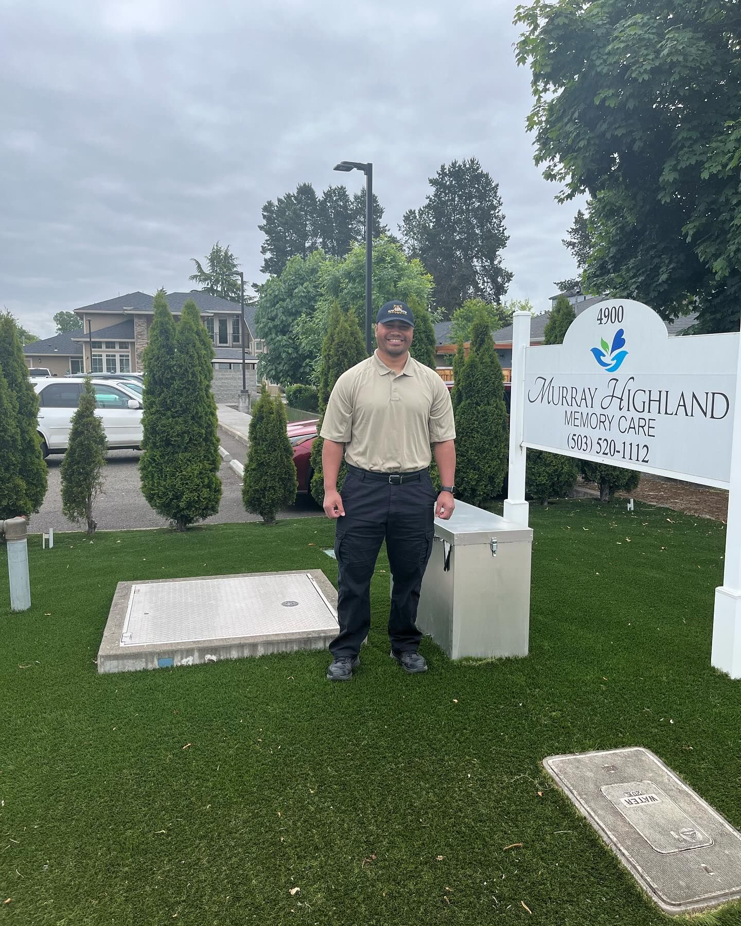 A man is standing in front of a sign in a cemetery.