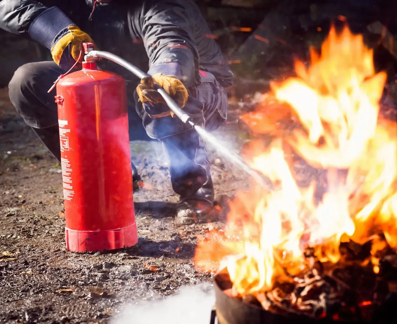 A man is using a fire extinguisher to put out a fire.