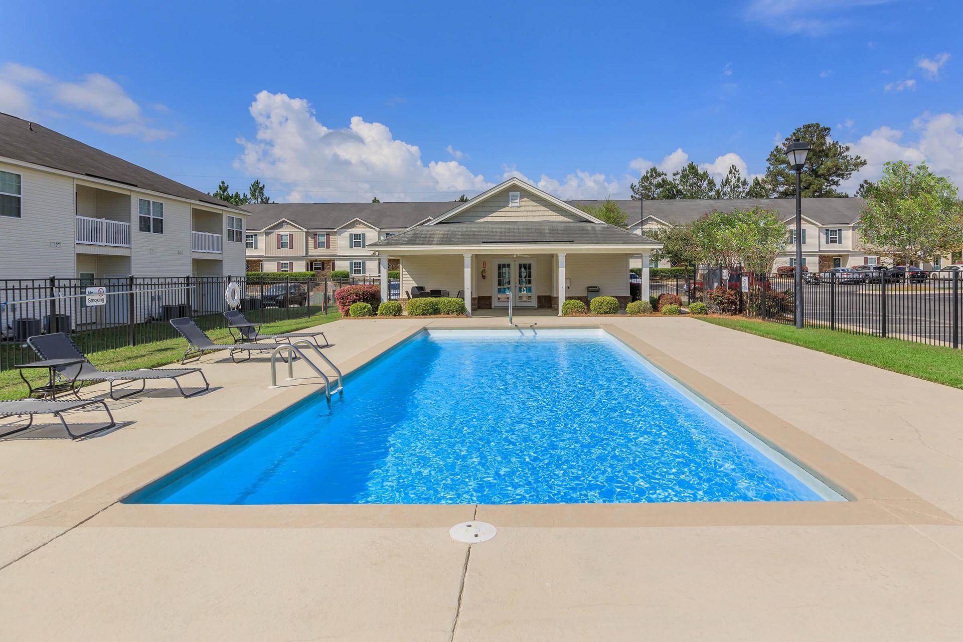There is a large swimming pool in front of a building.