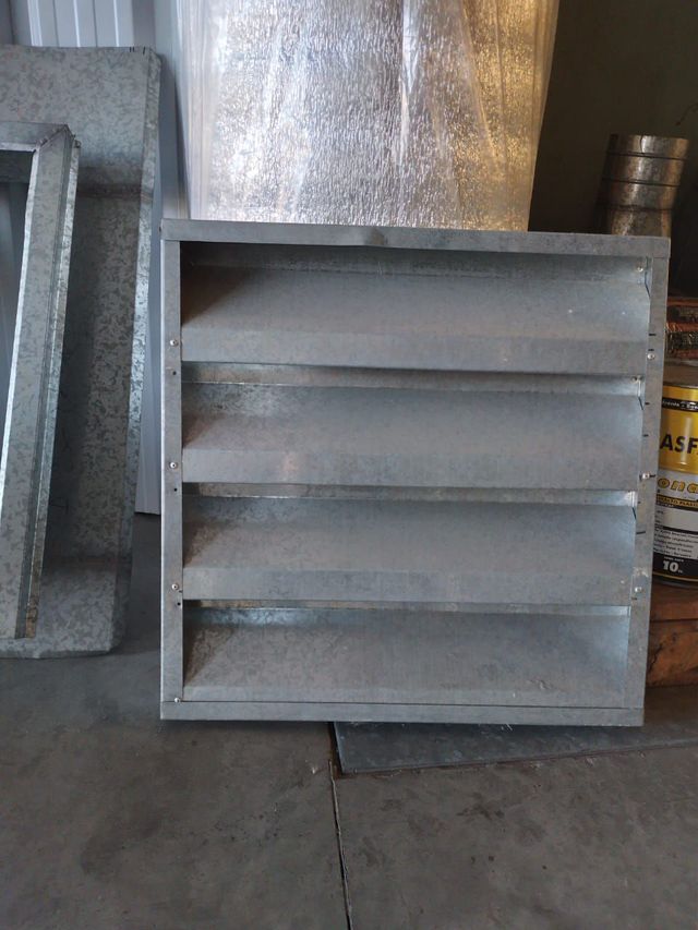 Rejilla de ventilación de metal gris con listones horizontales 