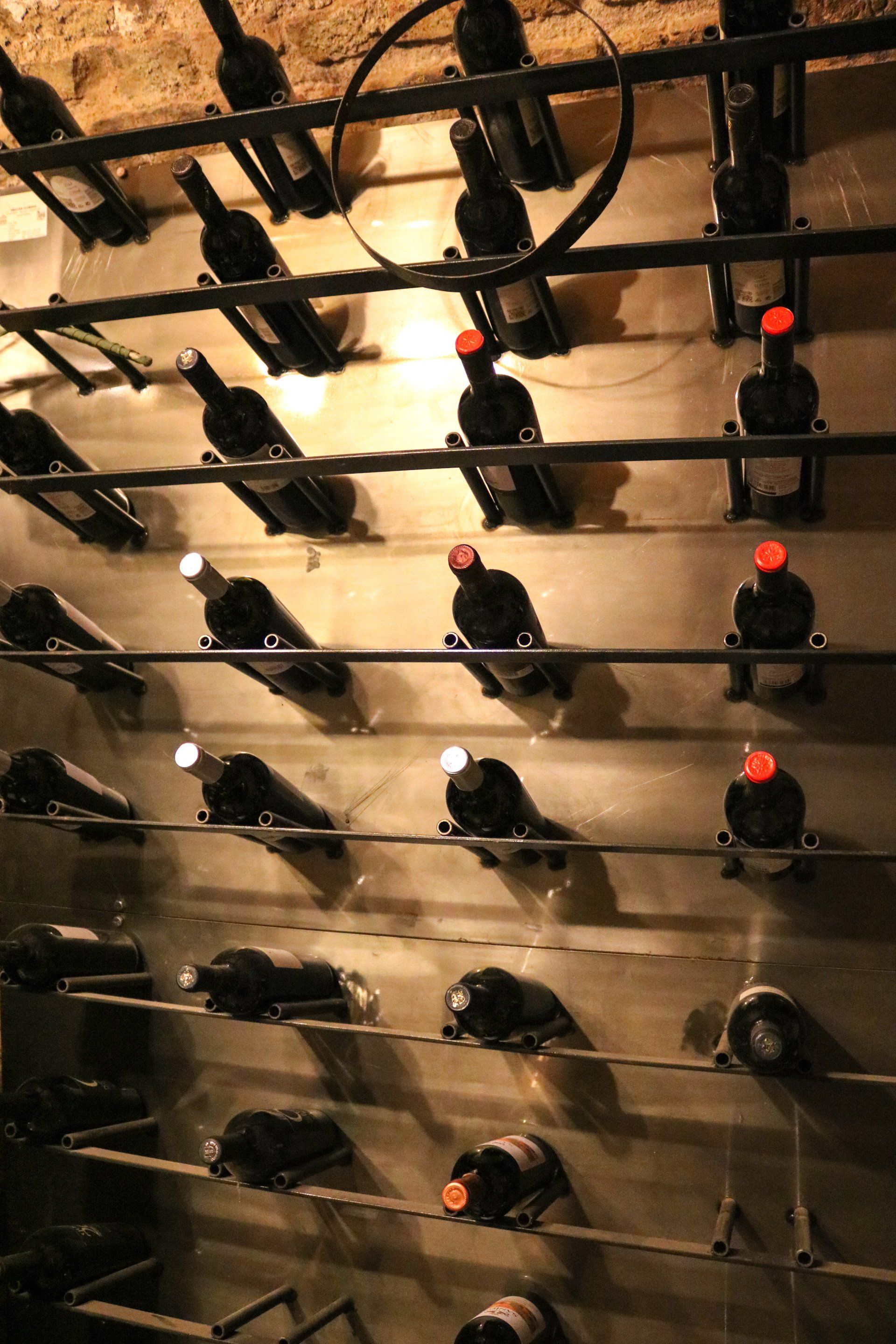 Eine Reihe von Weinflaschen hängen an einer Wand