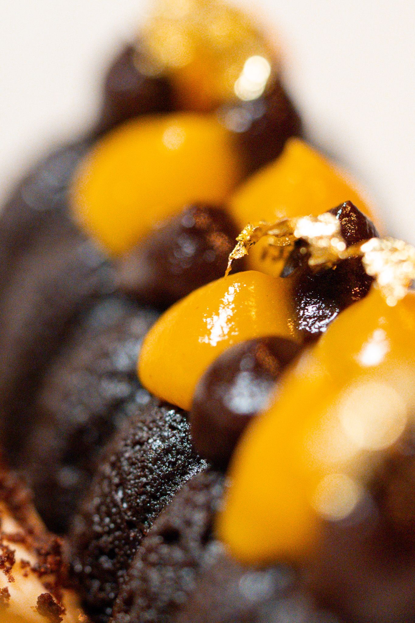 Dunkles Schokoladendessert mit Karamellsoße und Mango.