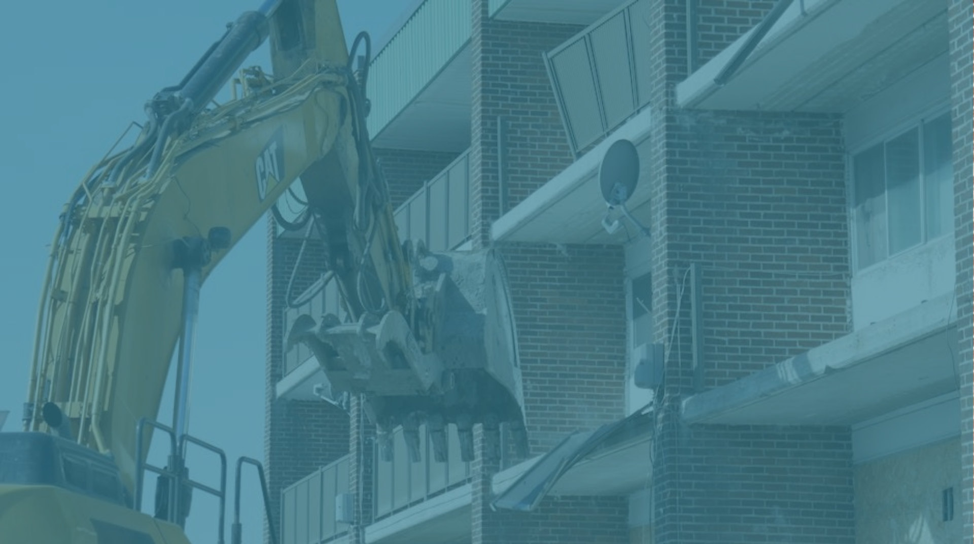 Building being demolished with excavator.