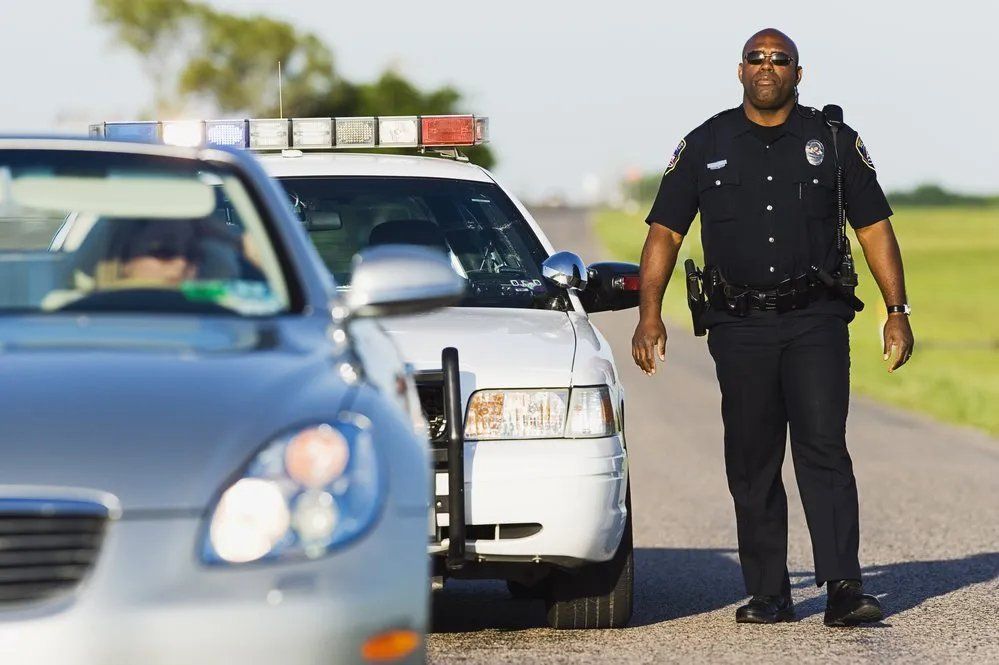 A police officer is stopping a car on the side of the road