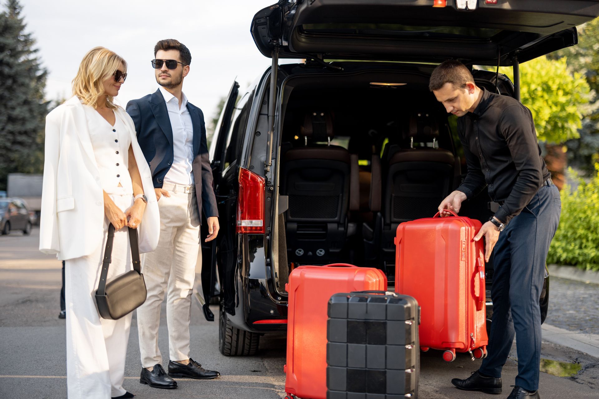 A man is loading luggage into the back of a van.