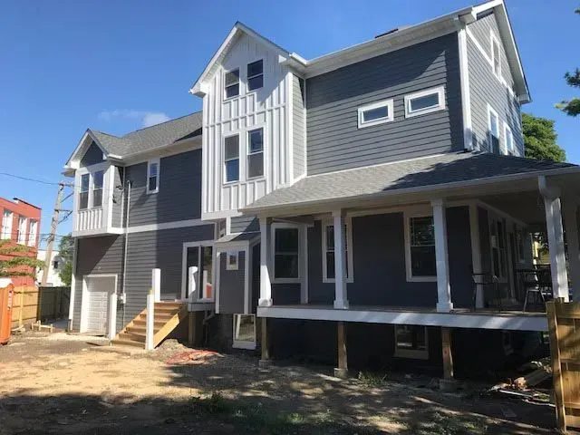 A large house with a large porch is being built.