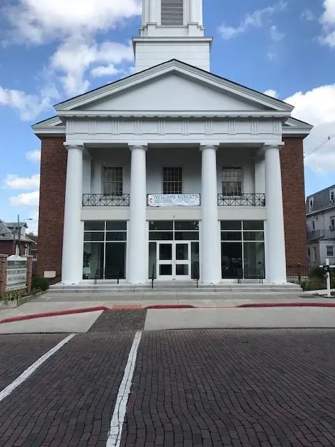 A large white building with columns and a clock tower