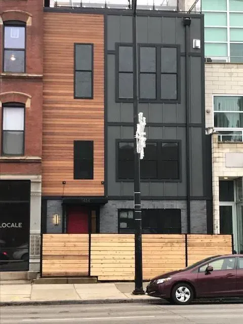 A purple car is parked in front of a building that says locale