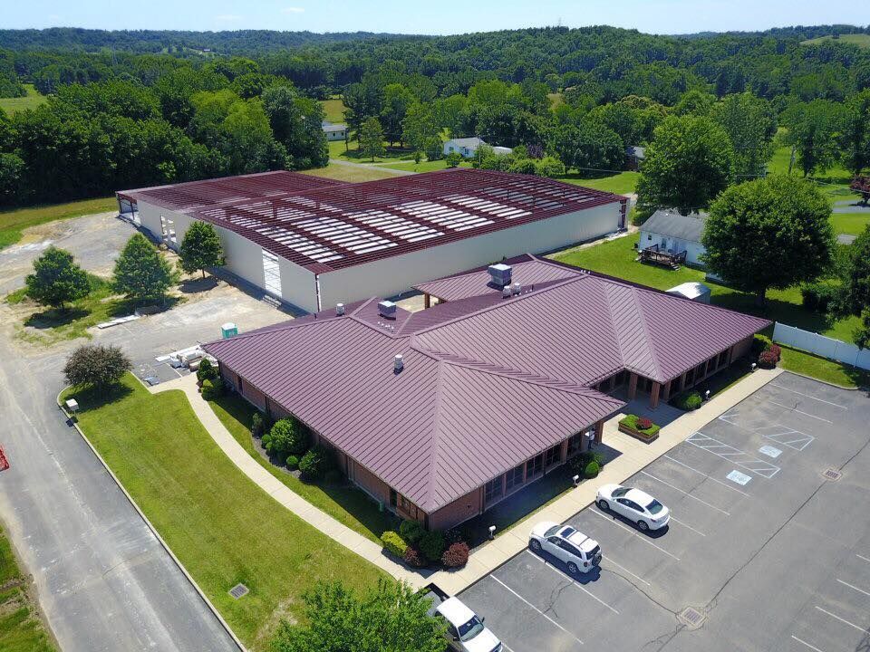 An aerial view of a building with a purple roof and a parking lot.
