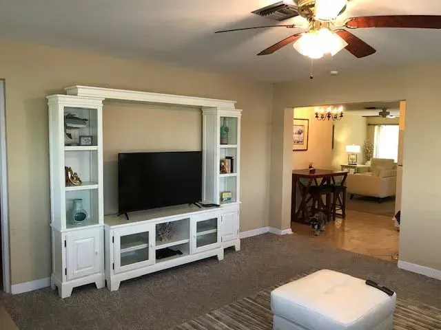 A living room with a television and a ceiling fan
