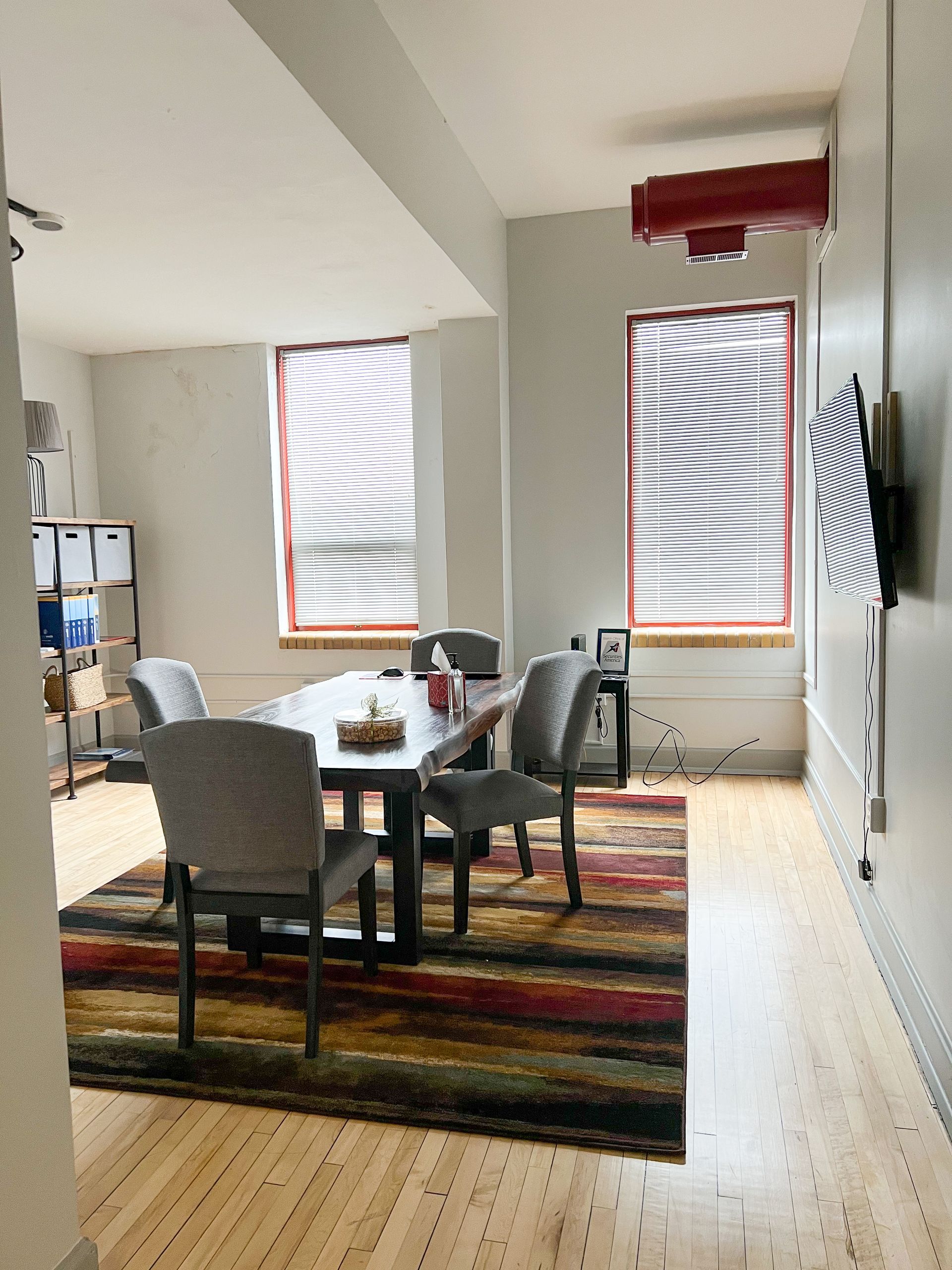 A dining room with a table and chairs and a rug