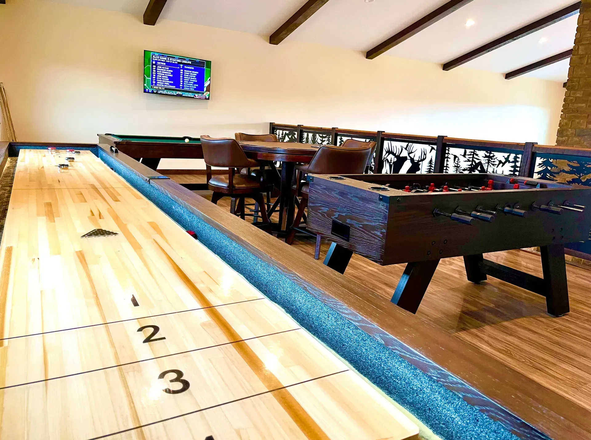 There is a shuffleboard table in the middle of the room.