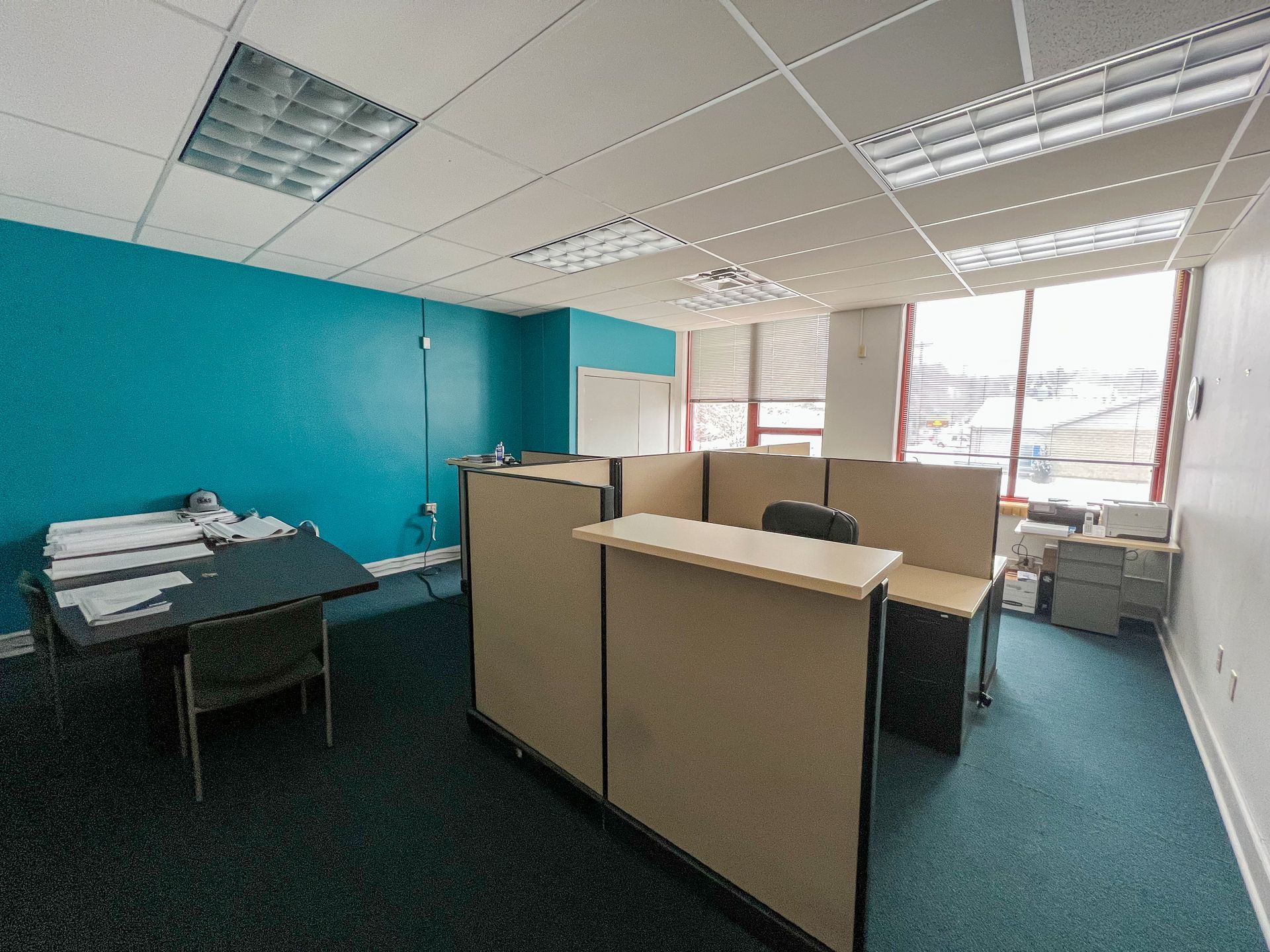 An empty office with cubicles and a desk