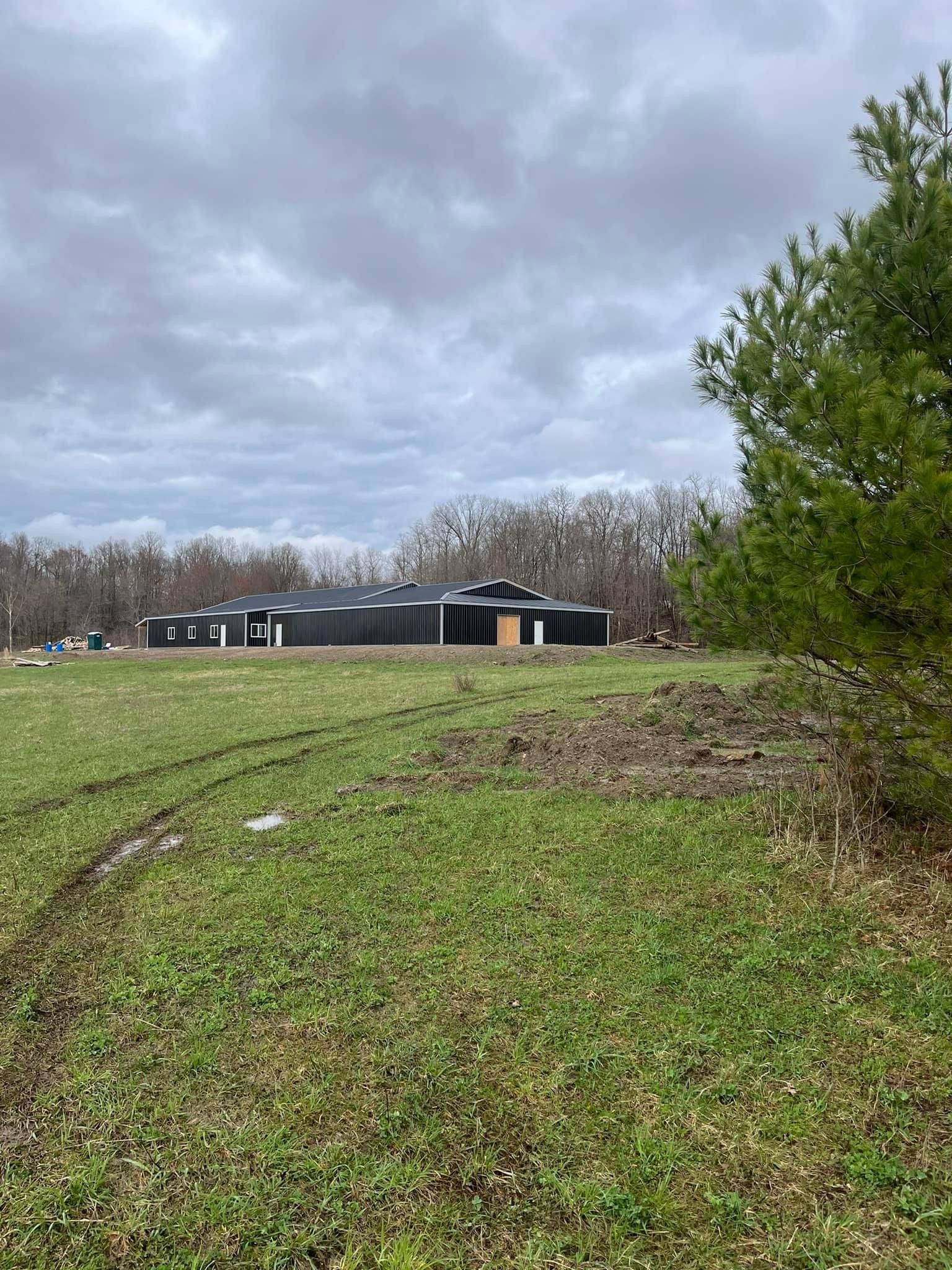 A large house is sitting in the middle of a grassy field.