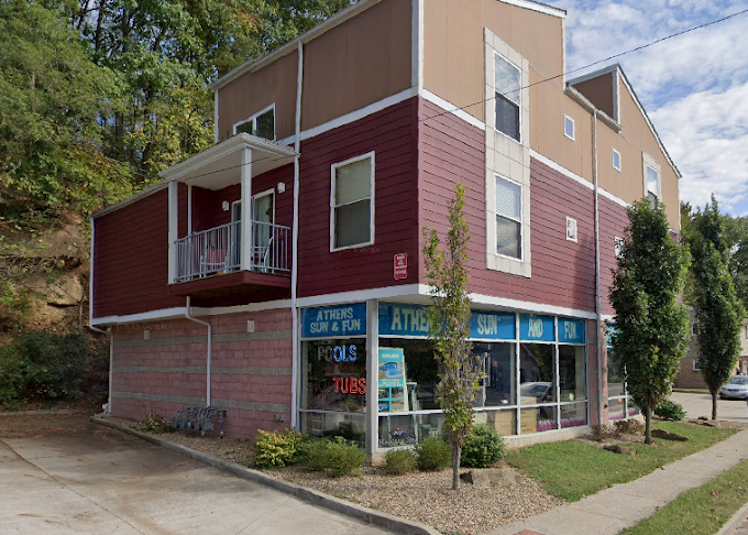 A red and tan building with a sign that says pools on it.