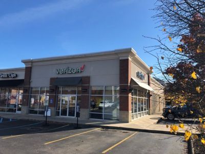 A verizon store with a car parked in front of it.