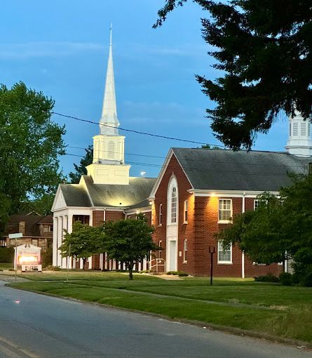 A church with a steeple is lit up at night