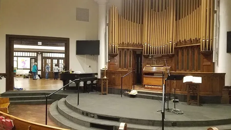 An empty church with a large organ in the background.
