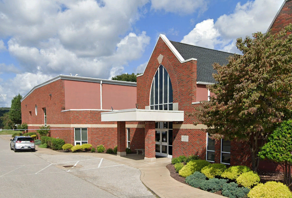 A large brick building with a car parked in front of it.