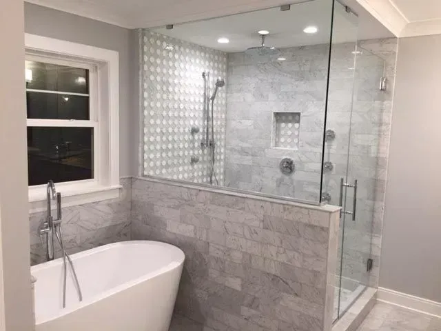 A bathroom with a bathtub and a walk in shower.