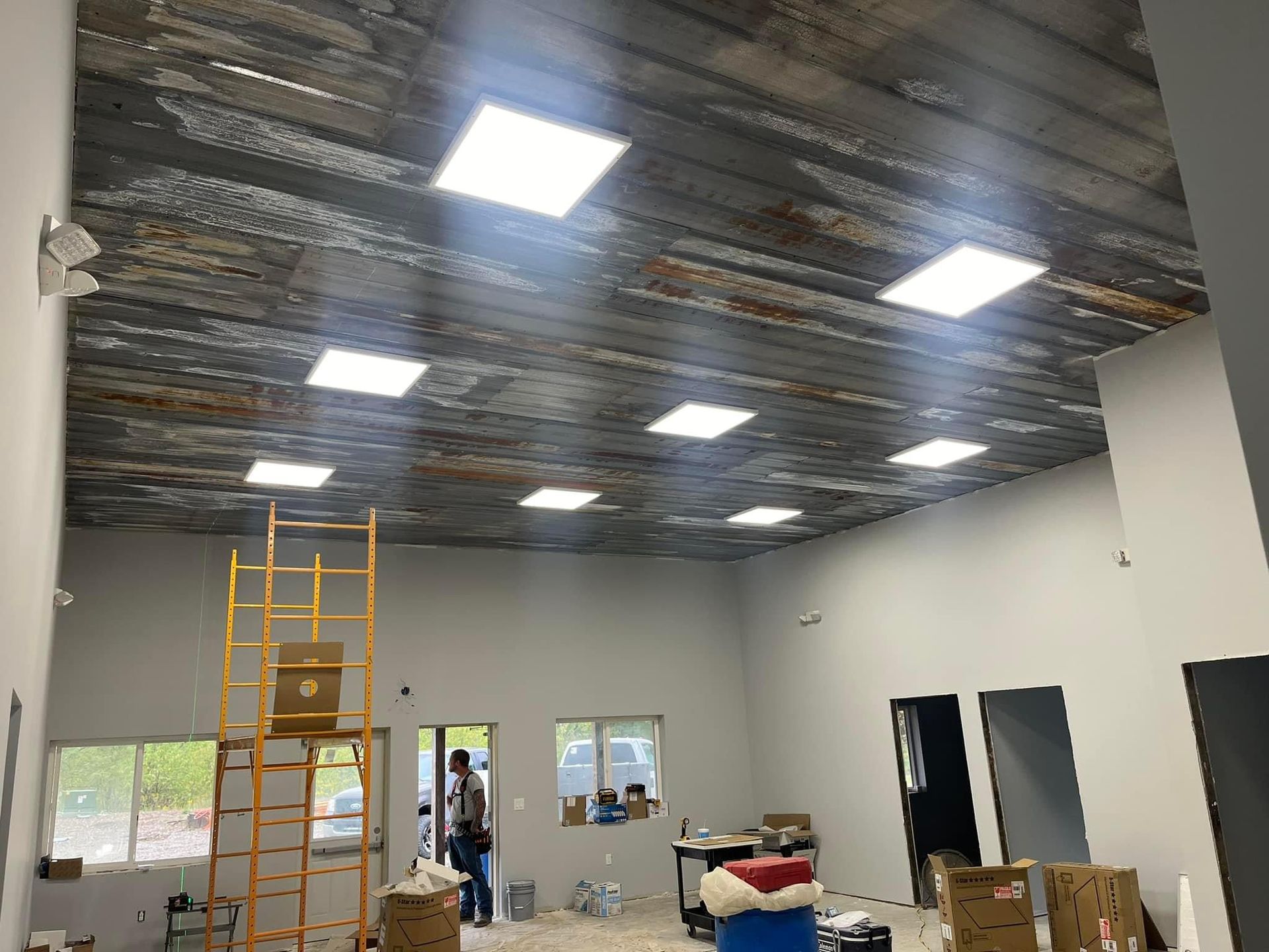 A large room with a wooden ceiling and square lights.