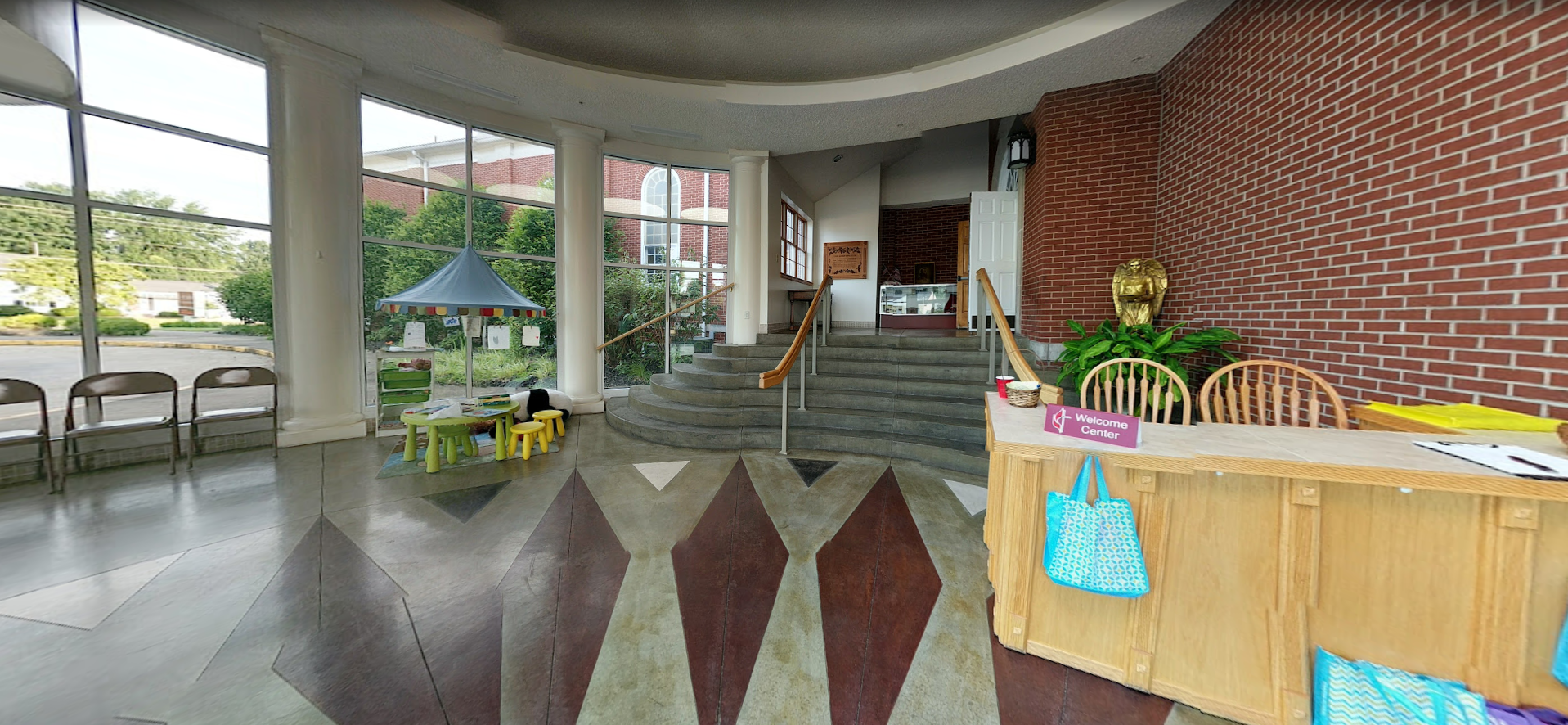 A large lobby with a brick wall and a wooden counter.