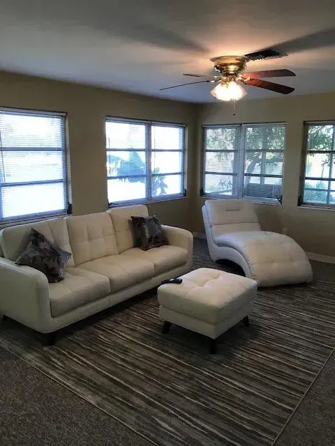 A living room with a couch , chair and ottoman