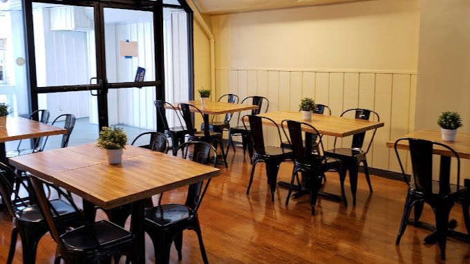 A restaurant with tables and chairs and a large window.