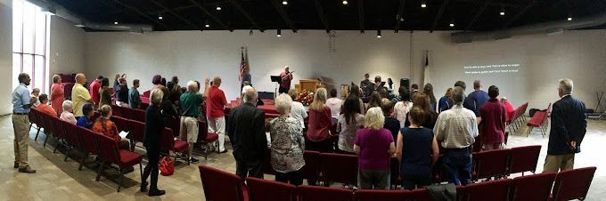 A large group of people are standing in a large room.