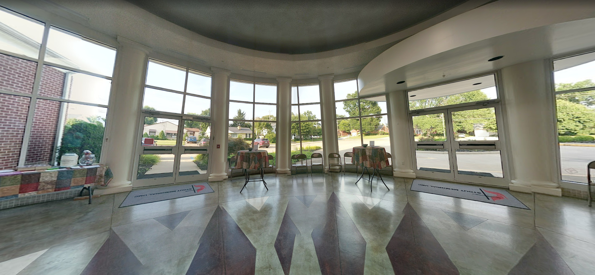 A large room with a lot of windows and a marble floor.