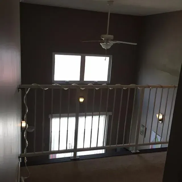 A room with a balcony and a ceiling fan