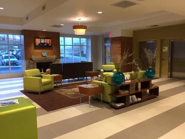 A living room with green chairs and a fireplace
