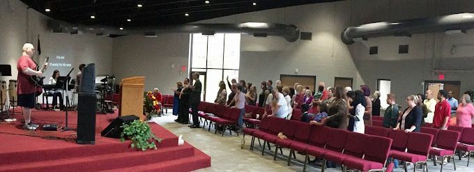 A large group of people are standing in a church.